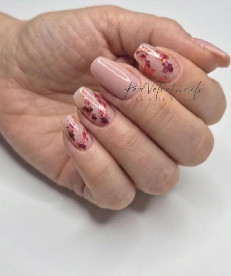Nude gel nails with flakes of red foil, a set by Red Velvet Nails